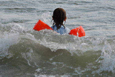Rear view of girl swimming in sea
