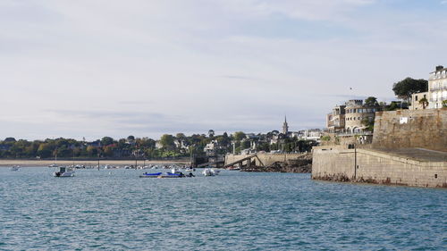 Scenic view of sea by buildings against sky