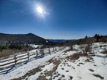 Scenic view of snow covered mountains against clear blue sky