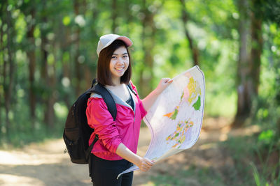 Woman holding umbrella while standing on land