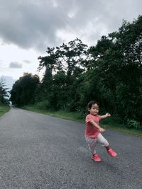 Side view of woman on road against sky