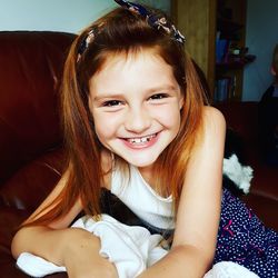 Close-up portrait of smiling girl sitting