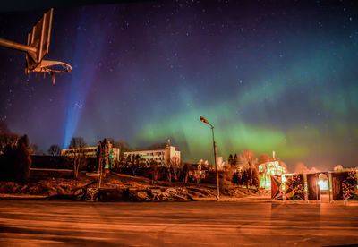 Low angle view of illuminated street against sky at night