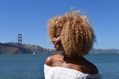 Portrait of woman by sea against sky