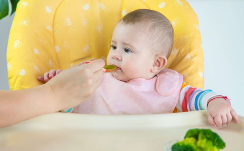 Portrait of cute baby boy eating food at home