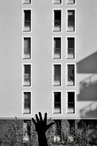 Close-up of hand against building