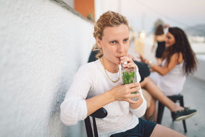 Woman drinking while sitting at cafe