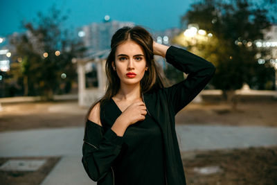 Portrait of beautiful young woman at night