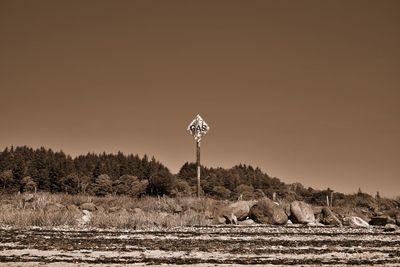 Windmill on field against clear sky