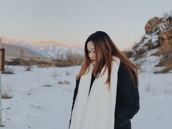 Woman standing on snow against sky