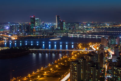 High angle view of city lit up at night