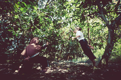 Rear view of people walking in forest