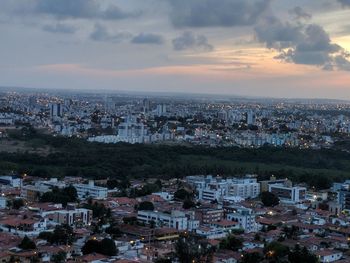 Aerial view of cityscape against cloudy sky