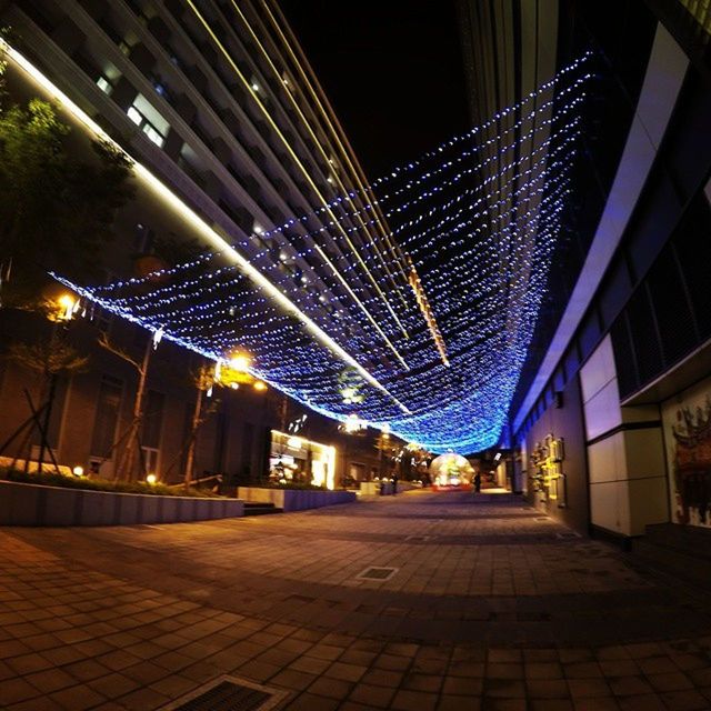 illuminated, night, architecture, built structure, building exterior, city, modern, lighting equipment, sky, outdoors, incidental people, low angle view, light - natural phenomenon, travel destinations, tree, no people, building, street light, city life, pattern