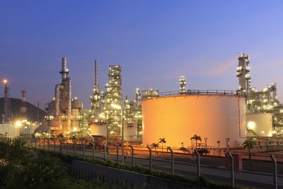 Illuminated factory against sky at night