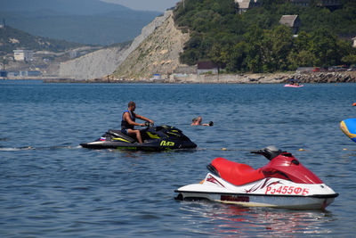 People in boat on lake against mountain