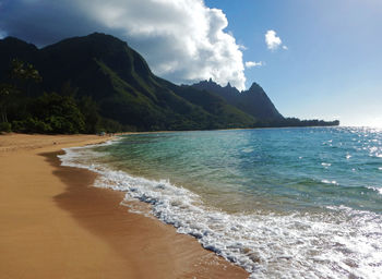 Scenic view of sea and mountains against sky