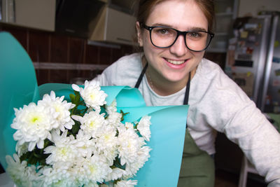 Portrait of young woman holding flowers