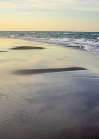 Scenic view of beach against sky during sunset