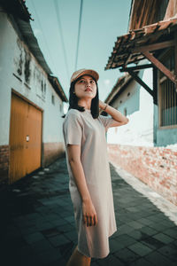 Portrait of young woman looking away while standing outdoors