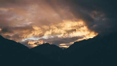 Scenic view of silhouette mountain against dramatic sky