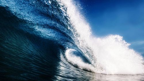 Sea waves splashing against blue sky