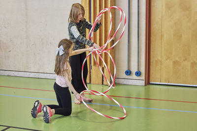 Children playing with hula hoops in school gym