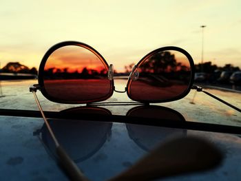 Close-up of sunglasses with reflection against sky