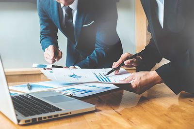 Midsection of colleagues working over graph in office