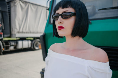 Close-up of beautiful woman standing by car