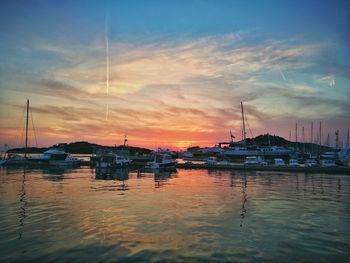 Sailboats in sea at sunset