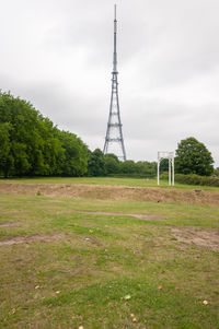 Electricity pylon on field against sky