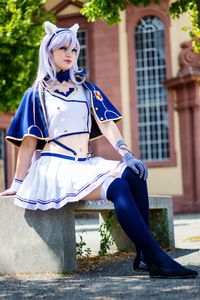 Low angle view of woman wearing cosplay costume looking away while sitting outdoors