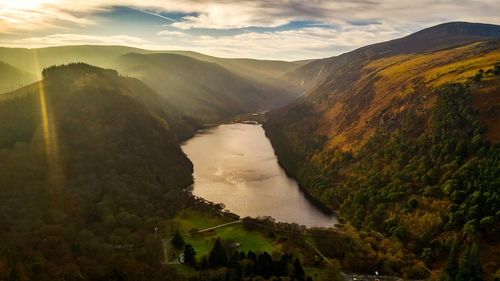 Scenic view of river amidst mountains against sky