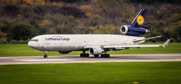 Side view of airplane at airport runway