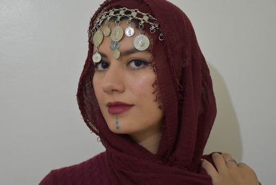 Close-up portrait of young woman against white background