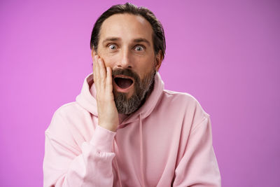 Portrait of mid adult man against pink background