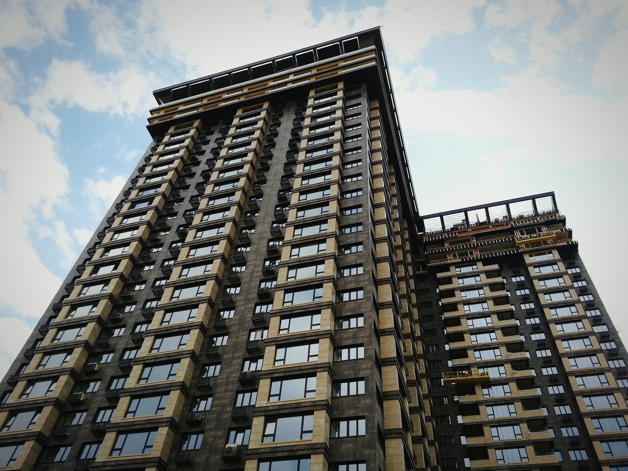 architecture, low angle view, built structure, building exterior, sky, cloud - sky, city, building, tall - high, window, cloud, tower, day, outdoors, no people, cloudy, modern, tall, office building, architectural feature