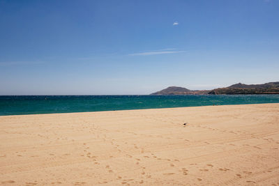 Scenic view of beach against blue sky