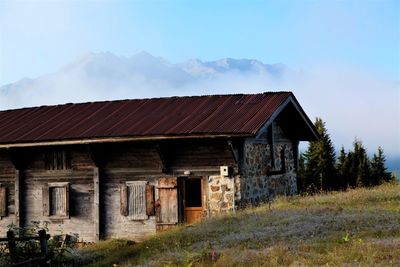 Abandoned house on field against sky