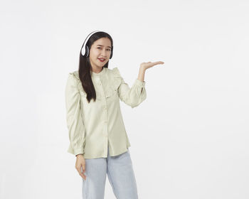 Portrait of smiling young woman against white background