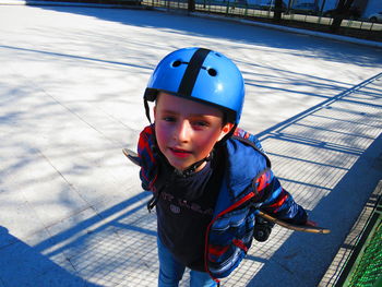 Portrait of boy wearing sports helmet standing at skateboard park