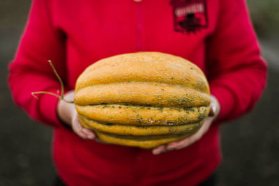 Midsection of man holding pumpkin