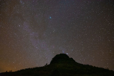 Low angle view of silhouette mountain against sky at night