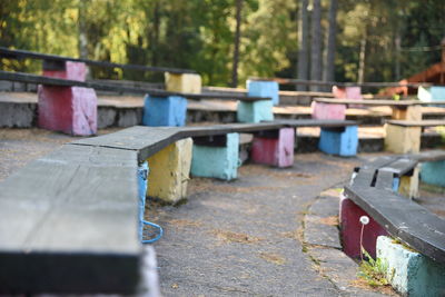 Close-up of multi colored chairs on table in forest