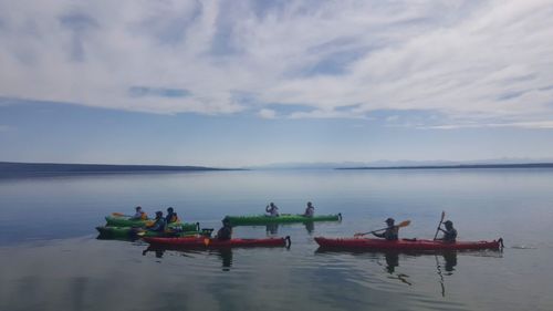 People in boat on sea against sky