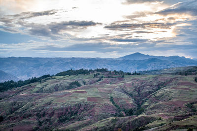 Mountains near trees and cloudy sky