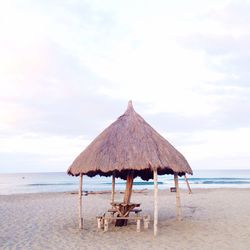 Lounge chairs on beach against sky