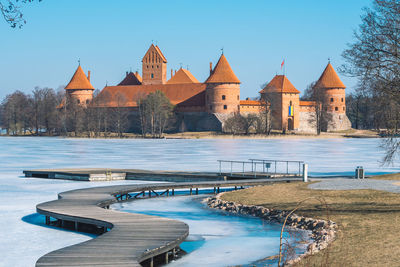 Medieval castle of trakai, vilnius, lithuania in winter with frozen lake and ukrainian flag