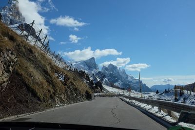 Road amidst snowcapped mountains against sky